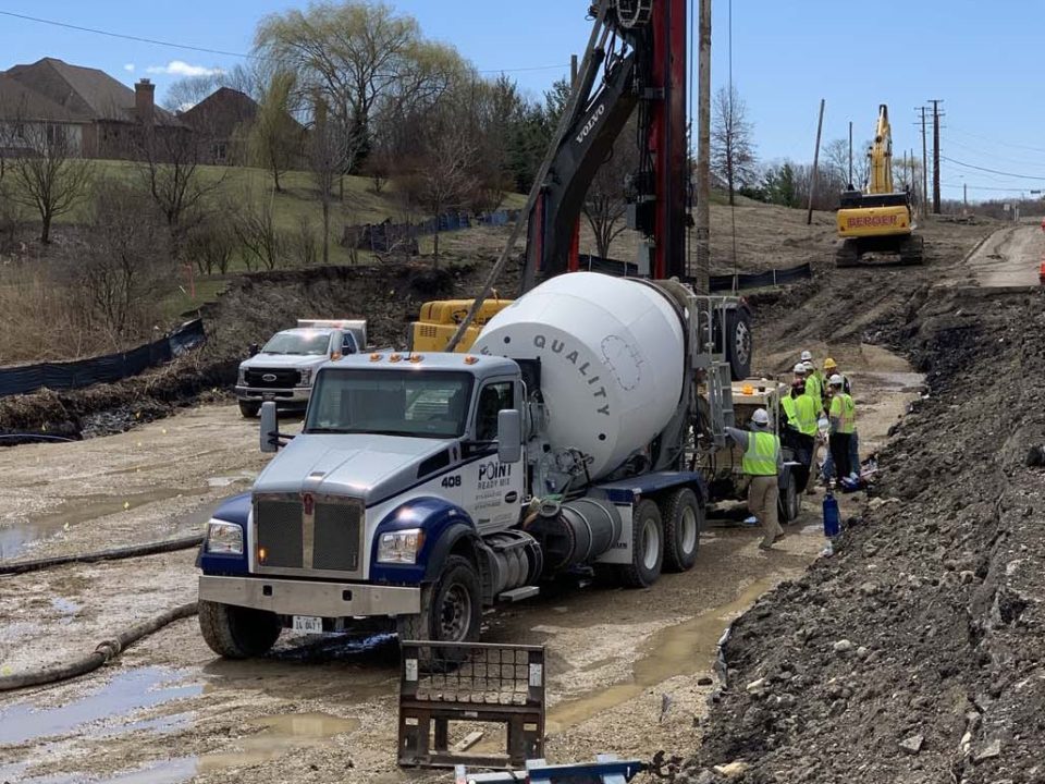 cement truck with workers in mud