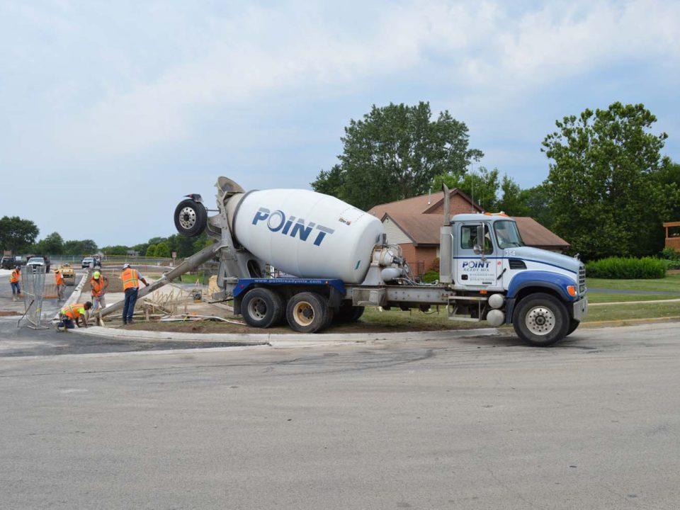 cement truck with workers in neighborghood